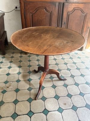 a small table with a wooden top on a tiled floor