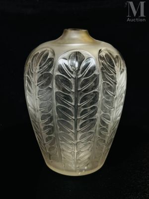 a glass vase that has a leaf design on it