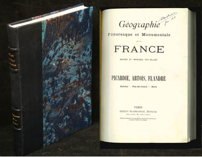 un livre ouvert posé sur une table à côté d'un livre