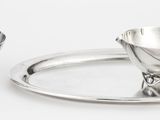 une tasse et une soucoupe en argent posées sur un plateau en argent