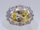 an image of a yellow diamond and diamond ring on a white surface