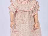 an image of a doll with a hat and dress on a white surface
