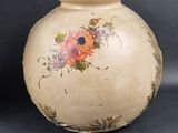 a vase with flowers painted on it sitting on a table