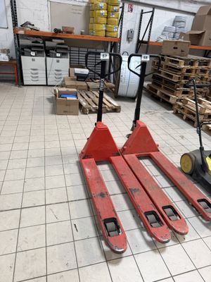 two forklifts that are sitting on the floor in a warehouse