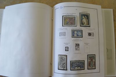un livre ouvert avec des timbres, posé sur une table