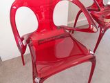deux chaises en plastique rouges placées l'une à côté de l'autre dans une pièce