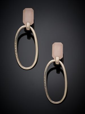a pair of earrings with a pink stone on a black background