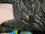 a black plastic bag full of clothes and other items