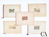 Plusieurs livres anciens sont disposés sur une surface blanche, avec un ruban rouge