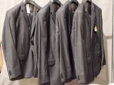 three suits hanging on a hanger in a room