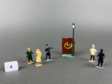 figurines représentant diverses personnes debout devant un panneau