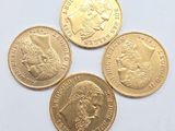 quatre types différents de pièces d'or reposant sur une surface blanche