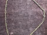 a close up of a necklace on a purple velvet surface