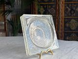 a glass plate sitting on a marble table with a gold stand