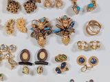 many different types of brooches and earrings on a white surface