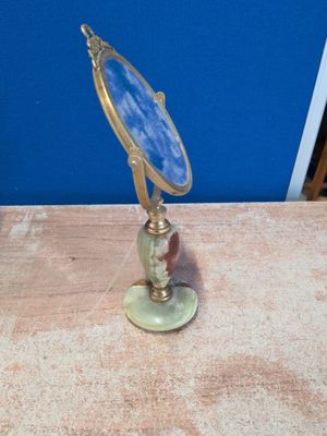 un petit miroir posé sur une table près d'un mur bleu