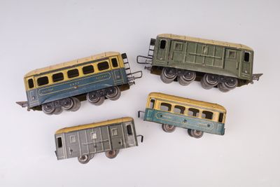 quatre petits trains miniatures posés sur une surface blanche