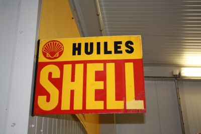 a sign that says hulls shell hanging from the ceiling