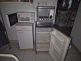 une photo d'une petite cuisine équipée d'un réfrigérateur et d'un micro-ondes