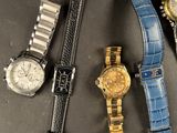 several watches are lined up on a table with a black background