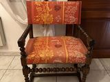 an old wooden chair with a red and yellow upholstered seat