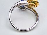 a close up of a ring on a white surface with a flower