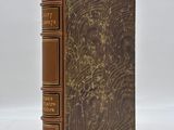 a brown book sitting on top of a white surface