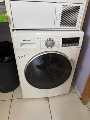 une machine à laver et un sèche-linge blancs, empilés l'un sur l'autre dans une pièce