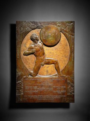 une plaque en bronze représentant un homme lançant une balle en l'air