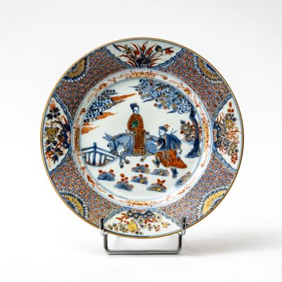 a blue and white plate with a picture of a man riding a horse