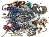 un tas de colliers et de bracelets de toutes sortes posés sur une surface blanche