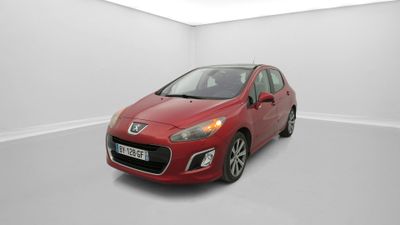 une voiture rouge est garée dans une pièce blanche