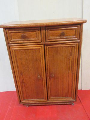 a small wooden cabinet with two drawers on top of it