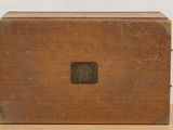 an old wooden box sitting on a table with a white wall in the background