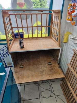 a cage with a shelf in the middle of a room