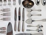 a lot of silver spoons and forks on the table