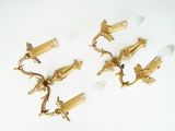 three antique brass wall sconces on a white background
