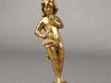 une figurine en or ancien représentant une femme tenant une fleur