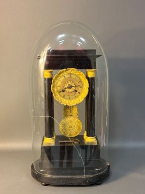 a small clock under a glass dome on a table