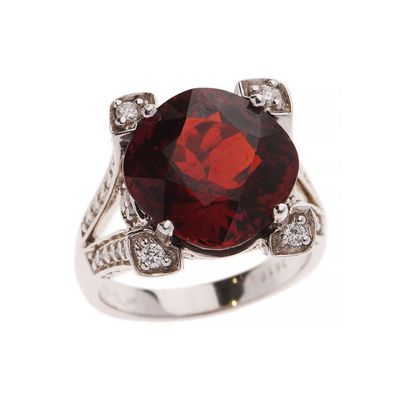 gros plan d'une bague avec une pierre rouge entourée de diamants