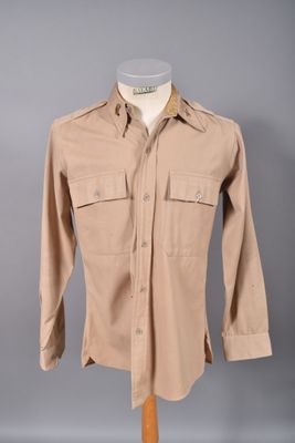 une photo d'une chemise beige sur un présentoir à mannequin