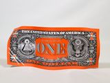 un billet d'un dollar de couleur orange posé sur une surface blanche