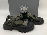 a picture of a pair of black and green sandals in front of a box
