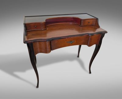 an antique writing desk with a glass top and wooden legs