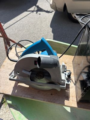 quelqu'un utilise une scie circulaire pour couper une pièce de bois