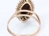 a close up of a gold ring with a brown stone in it