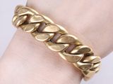 a close up of a person ' s hand wearing a gold bracelet