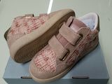 une paire de chaussures de bébé posée sur une boîte, elle-même posée sur une table