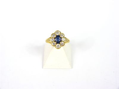 une bague en or jaune sertie d'un saphir bleu et de diamants blancs