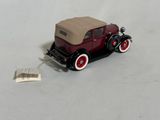 a small toy car with a beige top and red wheels